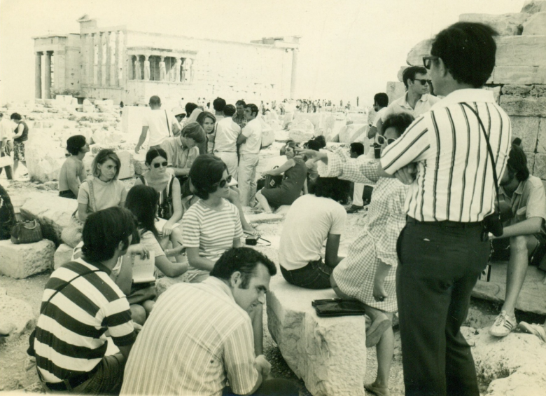 Dr. Ed Best lecturing on the Acropolis, Athens, Greece in front of the Parthenon,with a view of the Erectheum. 1970. 