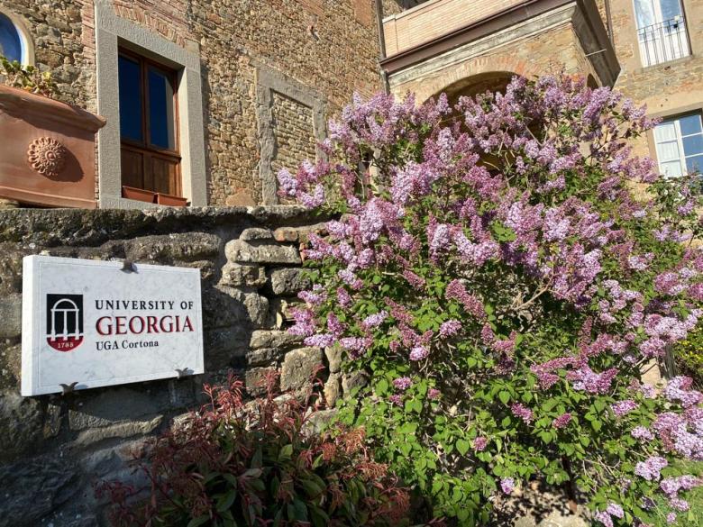 UGA at Cortona building and sign with blooming flowers